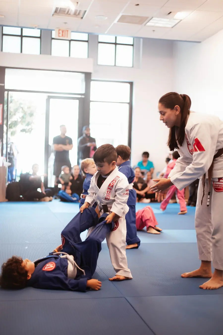 Professora acompanhando crianças no programa GBK Pequenos Campeões II da Gracie Barra Pituba